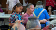 A father and daughter working on ceramics at the NAAC festival.