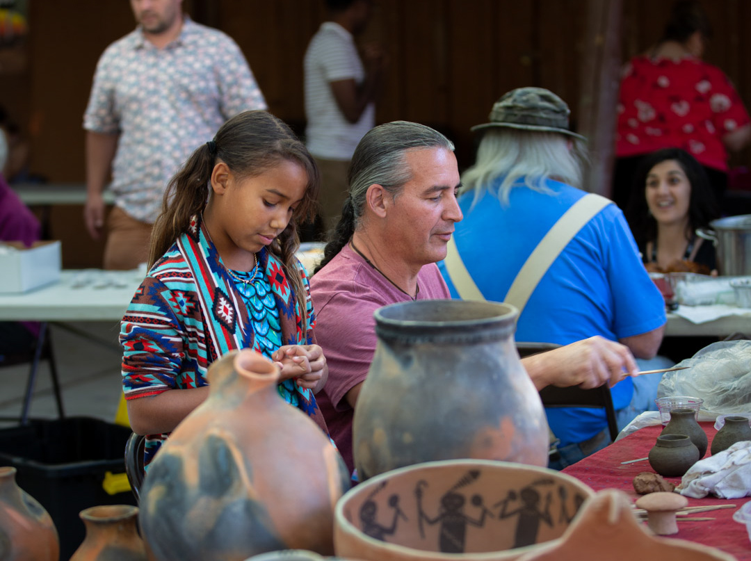 A father and daughter working on ceramics at the NAAC festival.