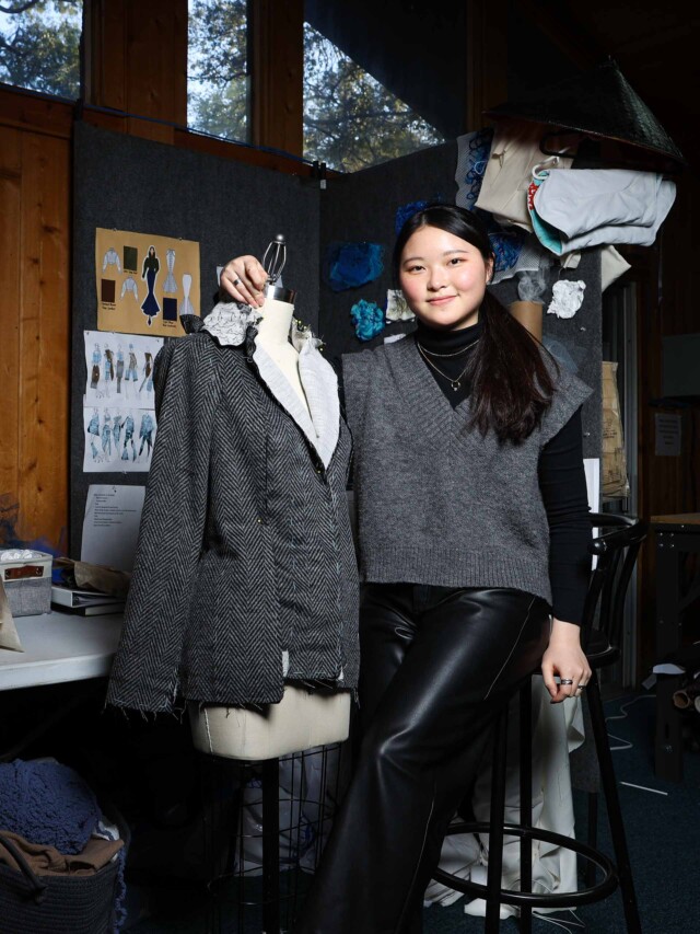 A fashion design student alongside her work.