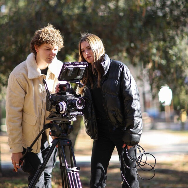 Two students filming outdoors.