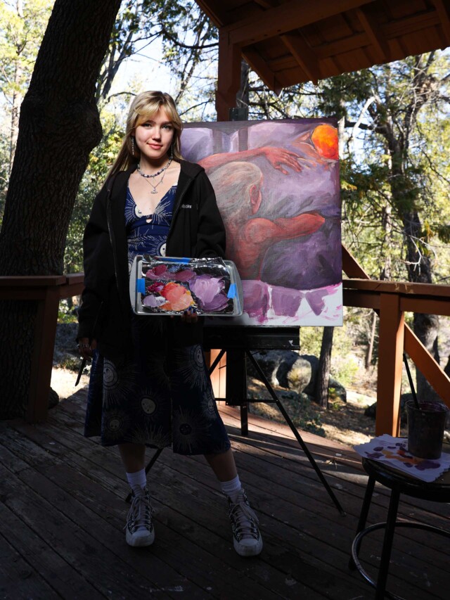 A visual arts student alongside her work.