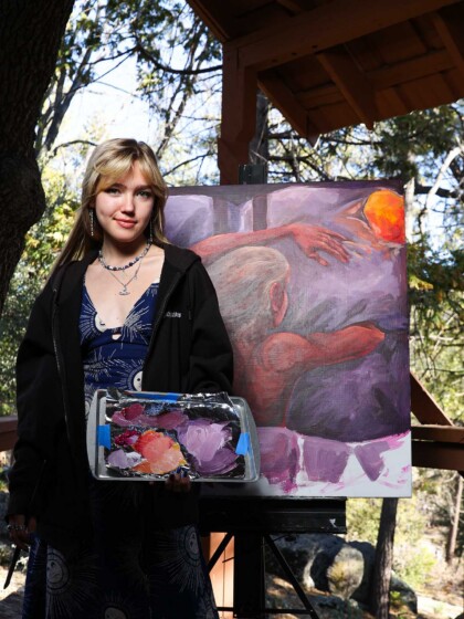 A visual arts student alongside her work.