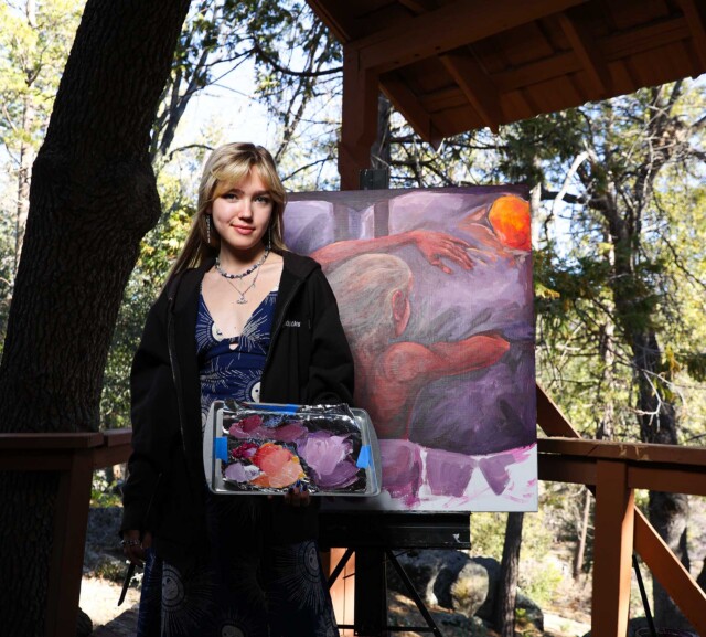 A visual arts student alongside her work.