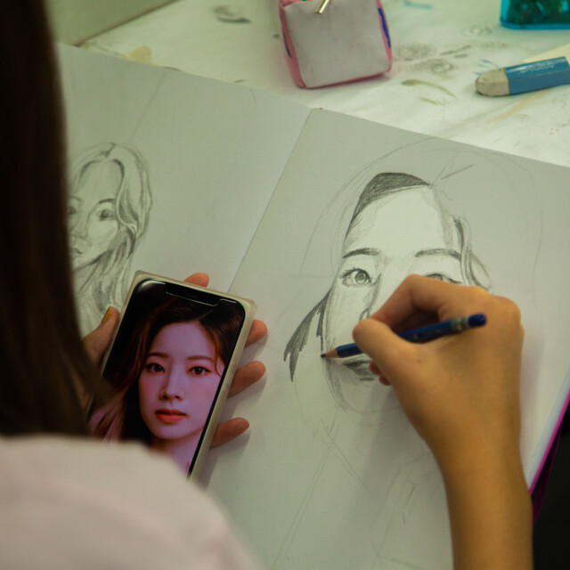 A visual arts student sketching a portrait.